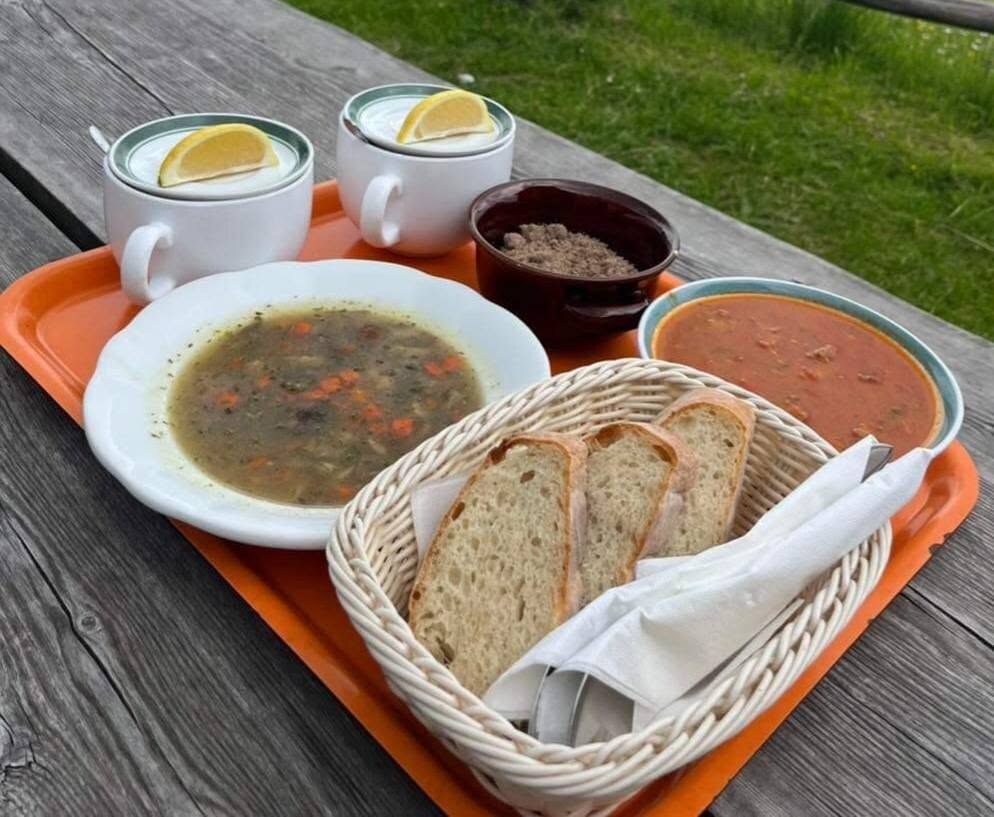 Dve juhi s kruhom in toplima napitkoma na pladnju