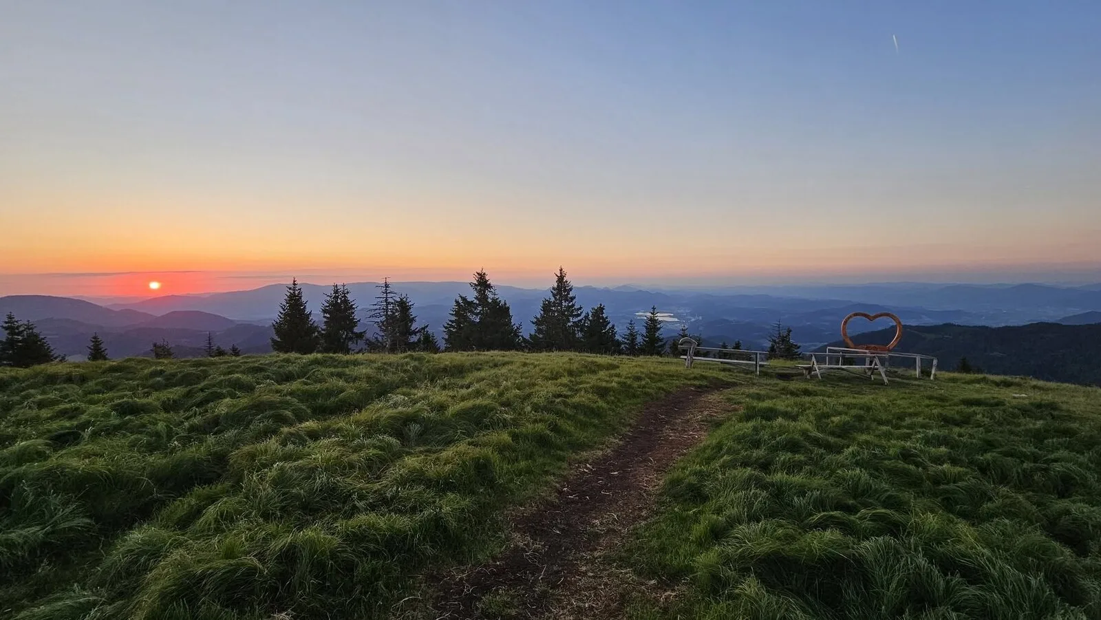 Sončni zahod nad travnato planino na Smrekovcu